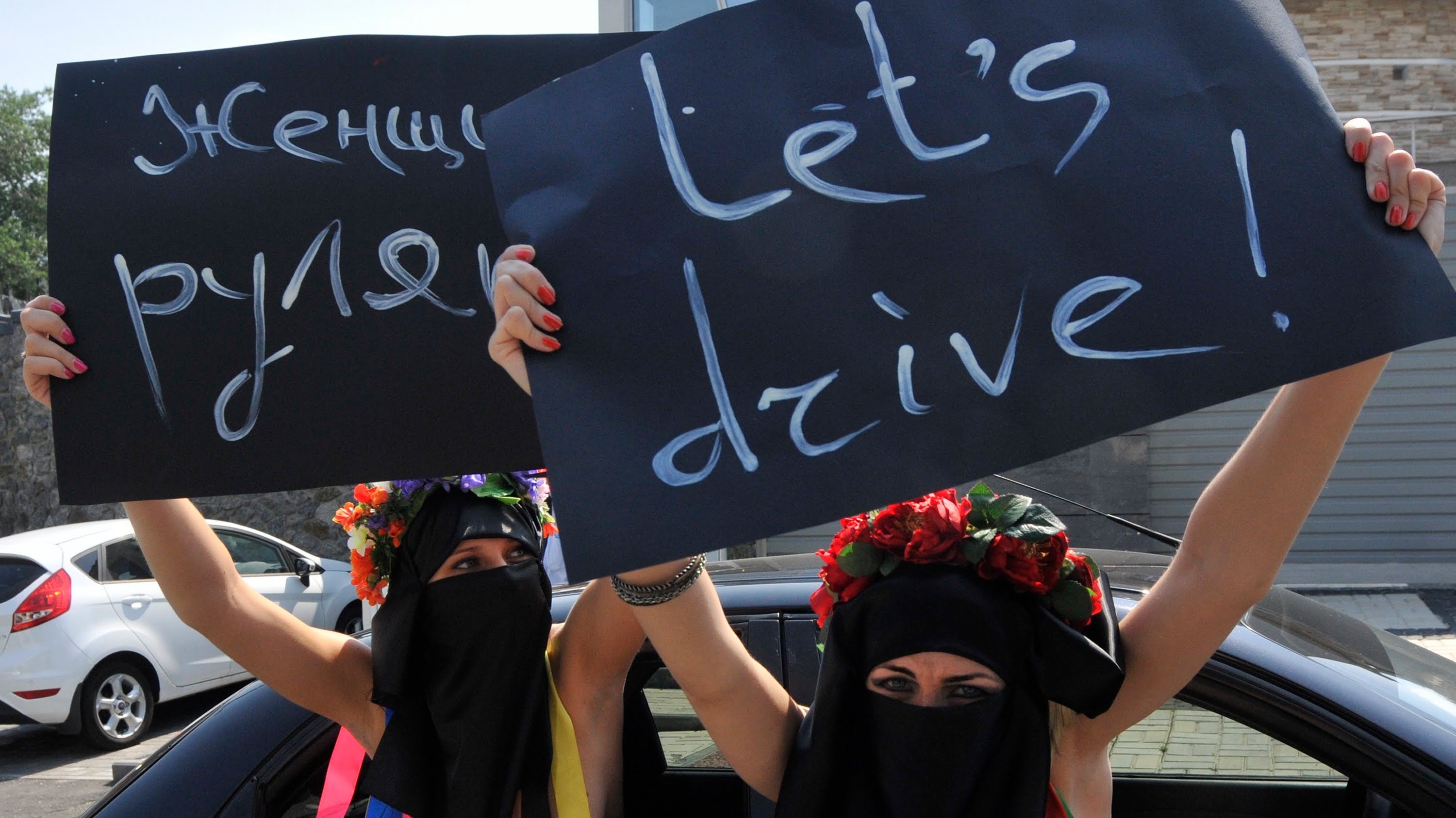 Women holding placards demanding the right to drive
