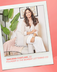 A poloroid photograph of Sanjana Chatlani sitting on the arm of a hair in her studio smiling at the camera with the text 'SANJANA CHATLANI, 32,FOUNDER @ THE BOMBAY LETTERING CO' underneath