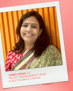 A poloroid photo of Umbu Aran in a saree smiling at the camera with the text '-UMBU ARAN, 47,TALENT MANAGEMENT HEAD @ ADITYA BIRLA CAPITAL' underneath