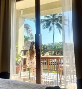 Image of a Saima Rahman looking out of a balcony, her back to the camera