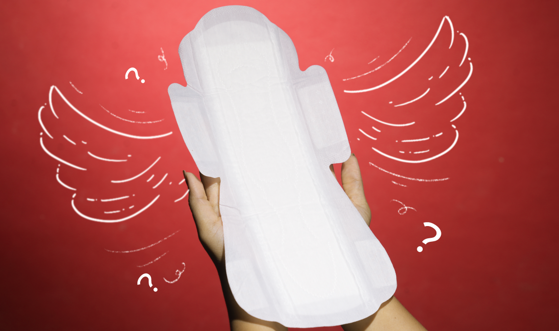 Hands holding a large sanitary pad with wings, against a red background. White doodles of wings and question marks surround the pad, emphasizing curiosity about its design.