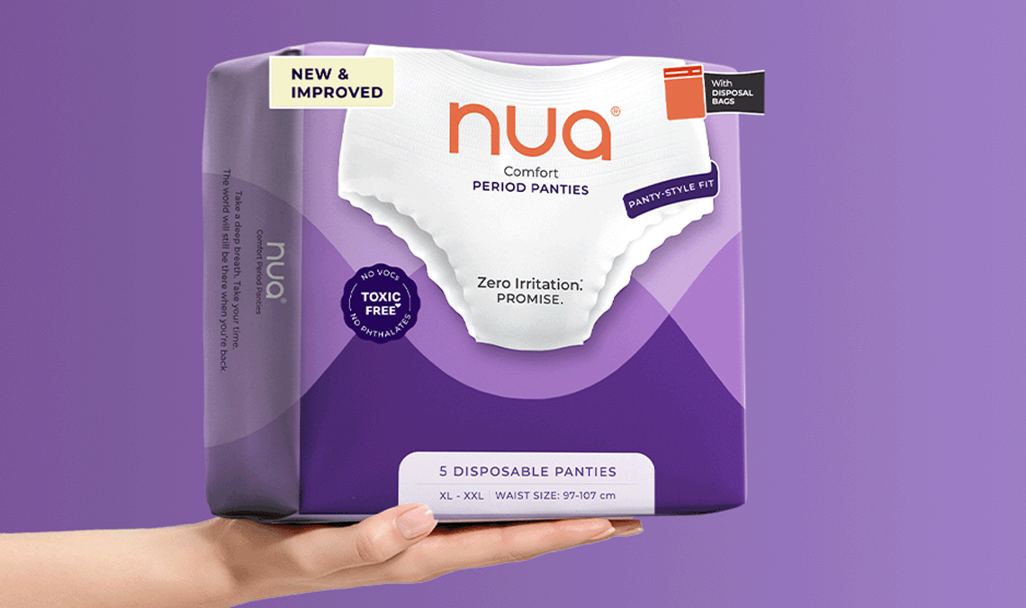 Hand holding a pack of Nua Comfort Period Panties against a purple background, highlighting disposable panties with disposal bags.