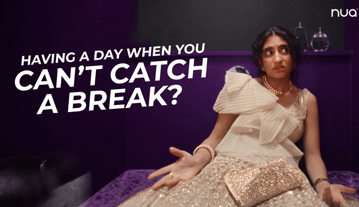 A woman in an embellished traditional outfit sitting on a sofa and gesturing with her hands, with text reading, “Having a day when you can’t catch a break?”